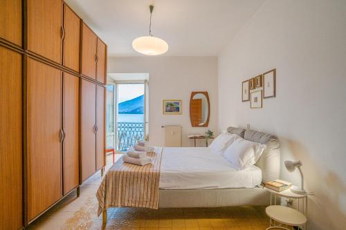 a bedroom with a bed and a balcony at GuestHost - Lovely Lakeview Flat in Central Dongo in Dongo
