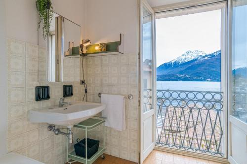 a bathroom with a sink and a large window at GuestHost - Lovely Lakeview Flat in Central Dongo in Dongo