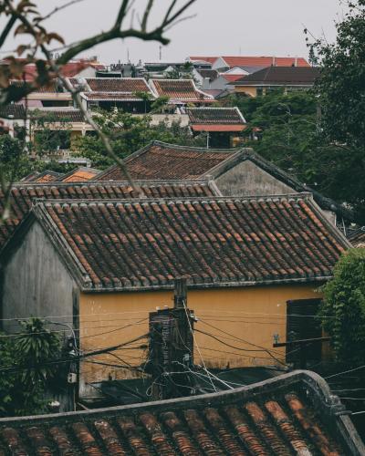 a group of buildings with roofs in a city at Savvy in Hoi An - The Essence of Refined Retreat in Hoi An