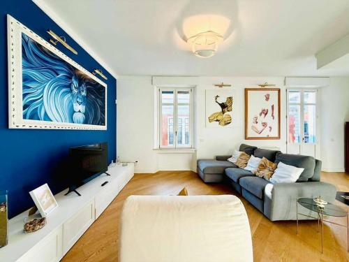 a living room with a couch and a blue wall at La Casa Del Pittore - Centro Storico in Legnano