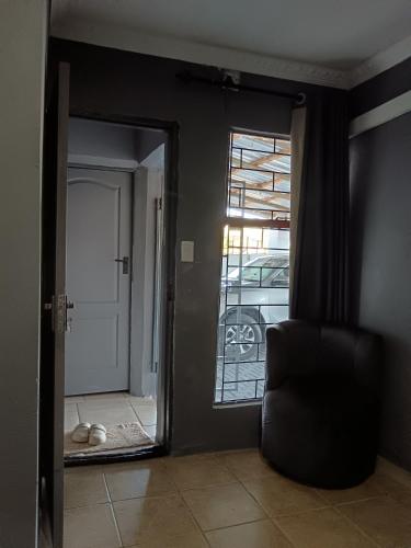 a living room with a chair and a door with a window at Ashridge Guesthouse & Safaris in Hazyview