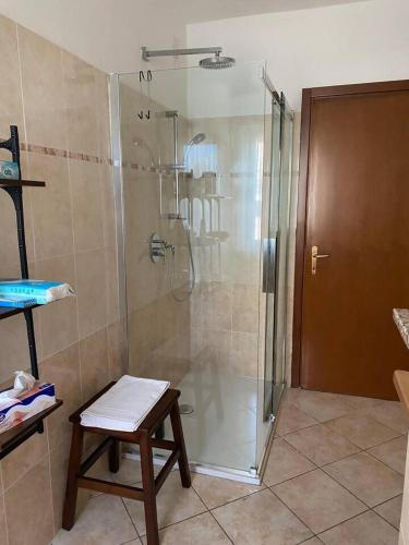 a shower stall in a bathroom with a wooden stool at Wellness in Malpensa - (check in entro le 22) in Samarate