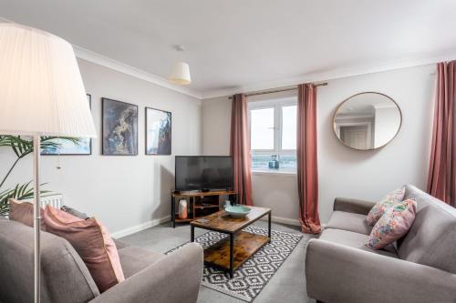 a living room with two couches and a television at Bay View - Donnini Apartments in Ayr