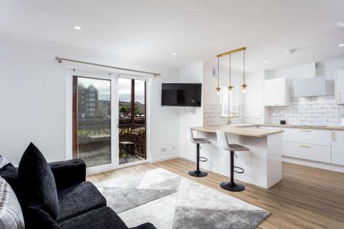 a kitchen and living room with a table and a couch at Harbour House - Donnini Apartments in Ayr