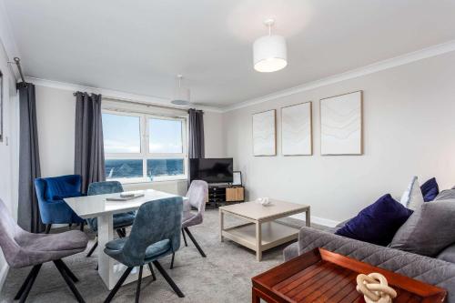 a living room with a couch and a table at Carrick Retreat - Donnini Apartments in Ayr