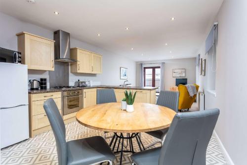 a kitchen and dining room with a wooden table and chairs at Elliot Suite No2 - Donnini Apartments in Ayr