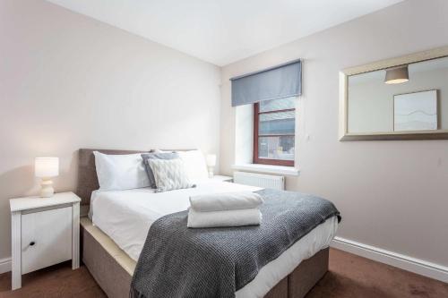 a white bedroom with a bed and a window at Elliot Suite No2 - Donnini Apartments in Ayr