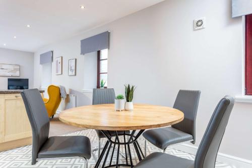a dining room with a wooden table and chairs at Elliot Suite No2 - Donnini Apartments in Ayr