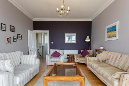 a living room with couches and a coffee table at Sea Breeze - Donnini Apartments in Ayr