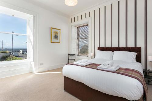 a bedroom with a bed and a large window at Sea Breeze - Donnini Apartments in Ayr