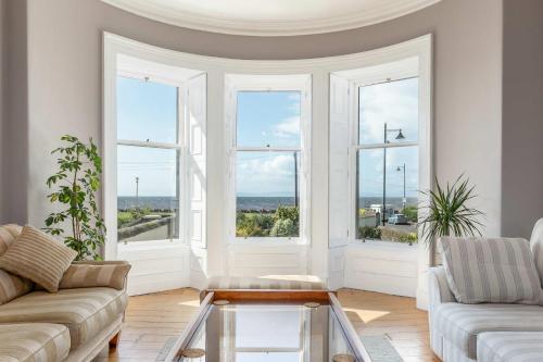 a living room with a couch and a glass coffee table at Sea Breeze - Donnini Apartments in Ayr