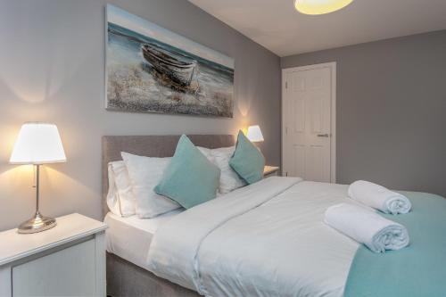 a bedroom with a bed with blue and white pillows at Forbes Retreat - Donnini Apartments in Ayr