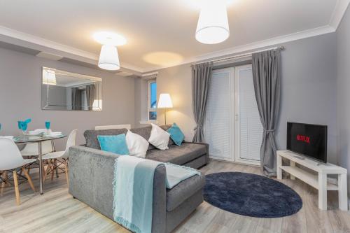 a living room with a couch and a tv at Forbes Retreat - Donnini Apartments in Ayr