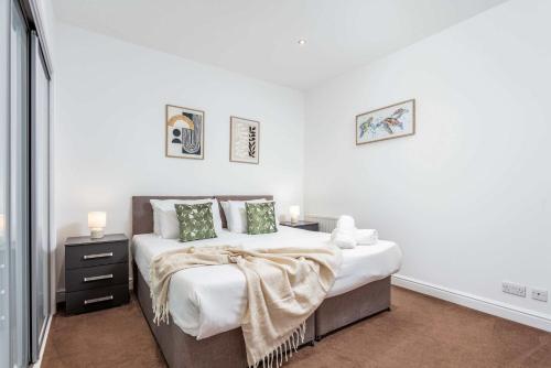 a white bedroom with a large bed with green pillows at Elliot Suite No 1 - Donnini Apartments in Ayr