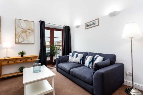 a living room with a blue couch and a table at Elliot Suite No 1 - Donnini Apartments in Ayr