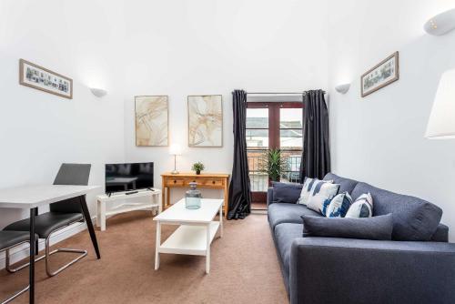 a living room with a blue couch and a table at Elliot Suite No 1 - Donnini Apartments in Ayr