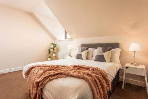 a bedroom with a large bed with a blanket on it at Elliot Suite No9 - Donnini Apartments in Ayr