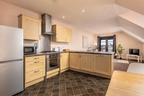 a kitchen with wooden cabinets and stainless steel appliances at Elliot Suite No9 - Donnini Apartments in Ayr