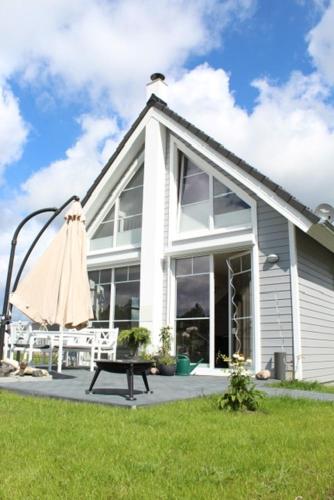 a white house with a picnic table and an umbrella at Hafenhaus Zerpenschleuse in Wandlitz