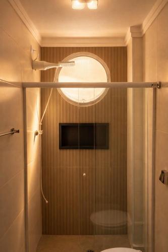 a shower with a glass door in a bathroom at Apê Completo - 300m da Praia in Guarujá