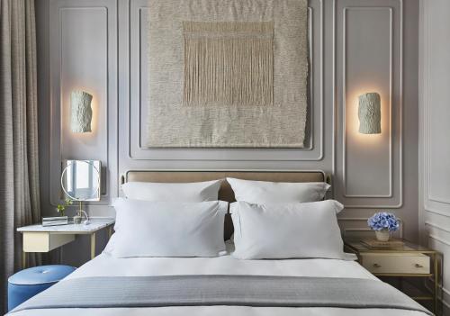 a bedroom with a bed with white pillows at One Aldwych in London