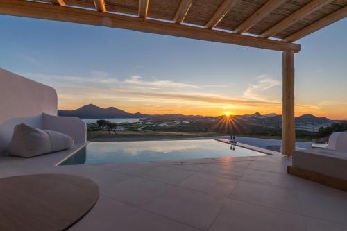a villa with a swimming pool and a sunset at Villa Leuki in Adamantas