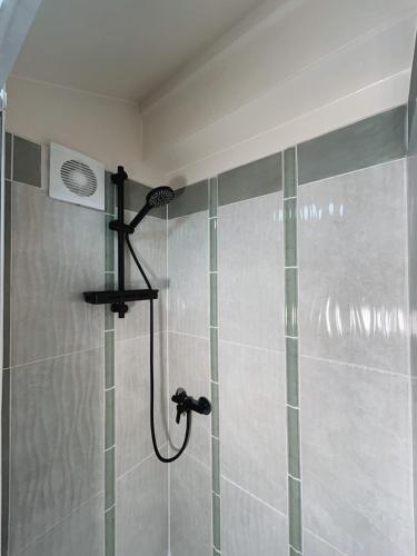 a shower with a shower head in a bathroom at Shifting Sands Surf House in Labenne