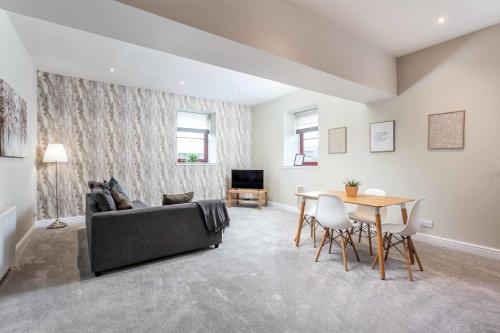 a living room with a couch and a table at Granary Suite No3 - Donnini Apartments in Ayr