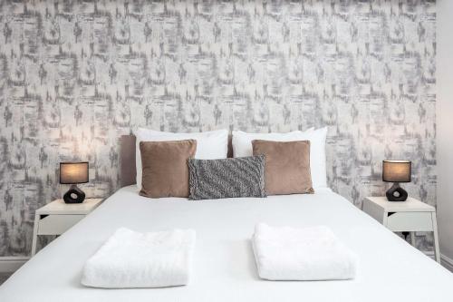 a bedroom with a white bed with two lamps at Granary Suite No3 - Donnini Apartments in Ayr