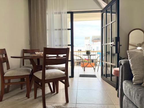 a living room with a table and chairs and a balcony at Casa DOS21 Boutique Apartments Playa Sur in Mazatlán