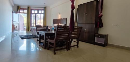 a dining room with a table and chairs in a room at Little Tibet Mcleodganj in Dharmsāla