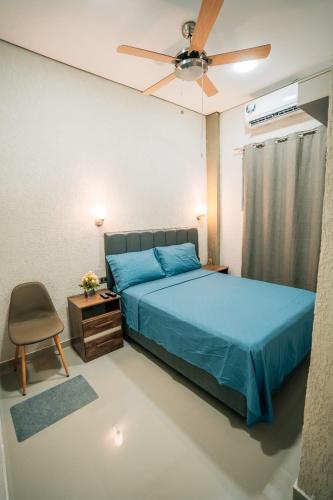 a bedroom with a blue bed and a ceiling fan at Hotel Urban Biz in Pilar
