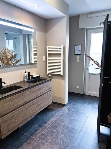 a bathroom with two sinks and a large mirror at Maison Malo in As
