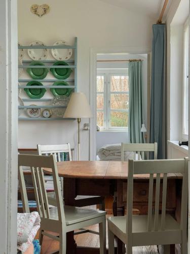 a dining room with a wooden table and chairs at Thatched Cottage Near Dronningmølle Beach in Dronningmølle