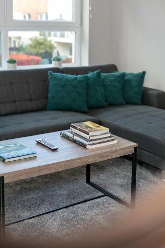 a living room with a coffee table with books on it at Iona Residence - Donnini Apartments in Ayr