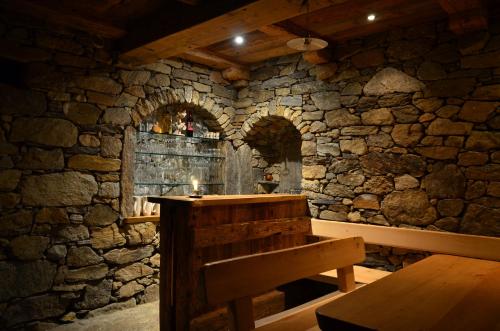 a stone room with a wooden table and a bench at Eichmannhof in Marlengo