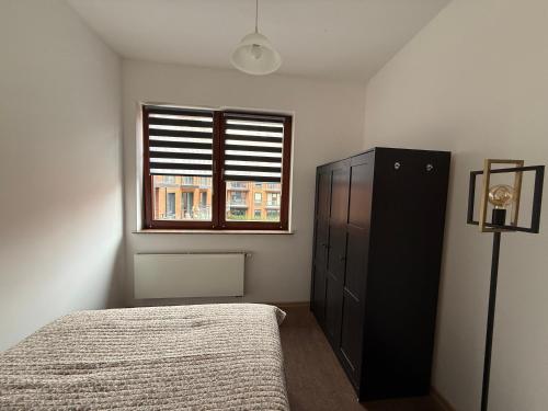 a bedroom with a bed and a window at JustInRent Family Szpitalna 4D-3 in Legnica