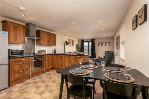 a kitchen with a table and chairs in a kitchen at Elliot Suite No7 - Donnini Apartments in Ayr