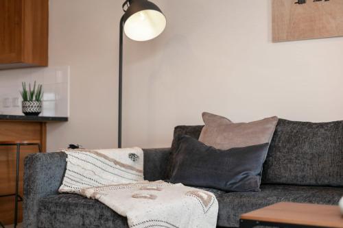 a living room with a gray couch with a pillow at Elliot Suite No7 - Donnini Apartments in Ayr