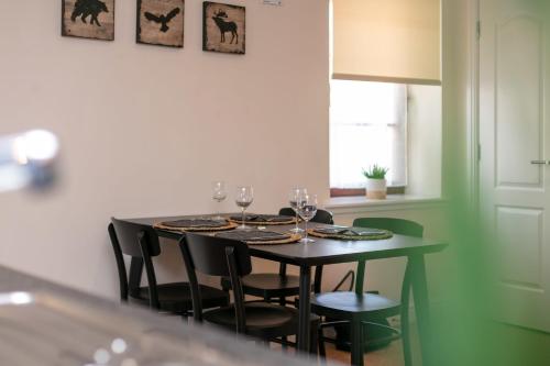 a dining room table with chairs and wine glasses at Elliot Suite No7 - Donnini Apartments in Ayr