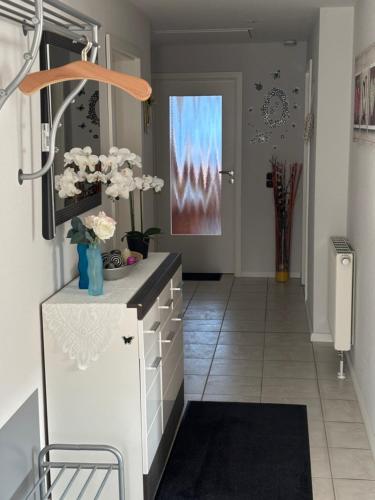 a hallway with a white cabinet with flowers in it at Ferienwohnung Hocke in Wulfsen