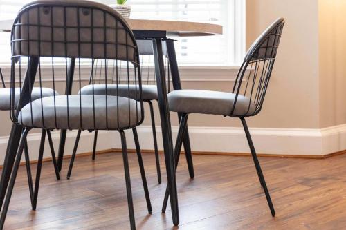 two black chairs sitting at a table in a room at Main Street View - Donnini Apartments in Prestwick