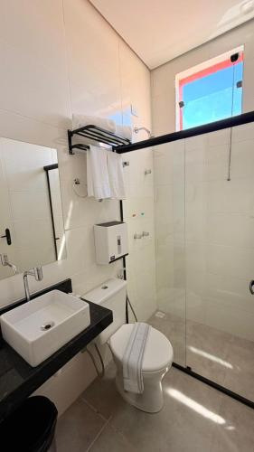 a white bathroom with a sink and a toilet at Chalés - Aquabeat in Sao Jose da Lapa