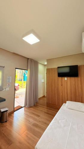 a bedroom with a bed and a flat screen tv at Chalés - Aquabeat in Sao Jose da Lapa