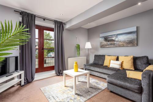 a living room with a couch and a tv at Elliot Suite No3 - Donnini Apartments in Ayr