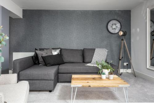 a living room with a gray couch and a table at Granary Suite No22 - Donnini Apartments in Ayr