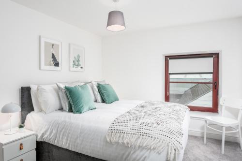 a white bedroom with a bed and a window at Granary Suite No22 - Donnini Apartments in Ayr