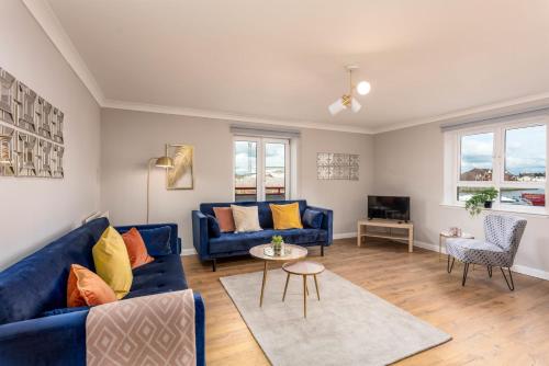 a living room with blue couches and a tv at Waverley Suite No57 - Donnini Apartments in Ayr