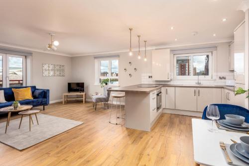 an open kitchen and living room with a blue couch at Waverley Suite No57 - Donnini Apartments in Ayr