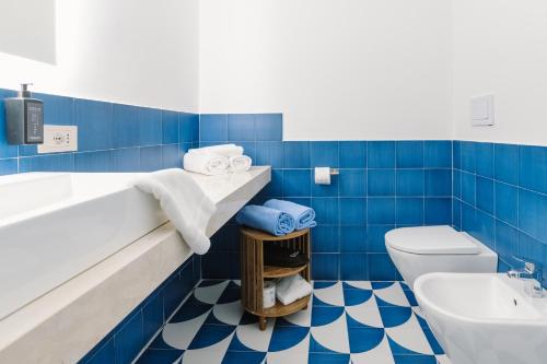 a blue and white bathroom with a sink and a toilet at Hotel Rivage in Sorrento